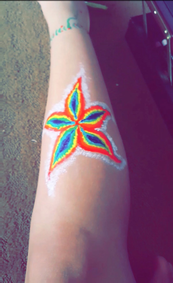 Sophomore Coraima Banales showcases one of her creations on her leg. Banales frequently paints designs on her body as a way to express her artistic talent.