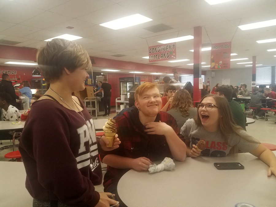 Sophomore Maycie Meaders tells a joke that made junior Mikeal Williamson and senior Emily Knox laugh and smile. One of the challenges for the day was to make five people smile with random acts of kindness.