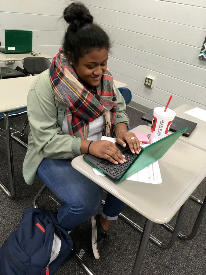 Junior Fai Thomas works on her Chrome Book during her 6th period class. She wore green to support suicide prevention day at the school.