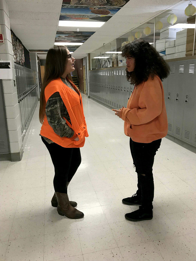 Sophomores Destiny Calivere and Gabrielle Vaoifi chat during the first day of Courtwarming Spirit Week. Today was Class Color Day with sophomores sporting orange attire.