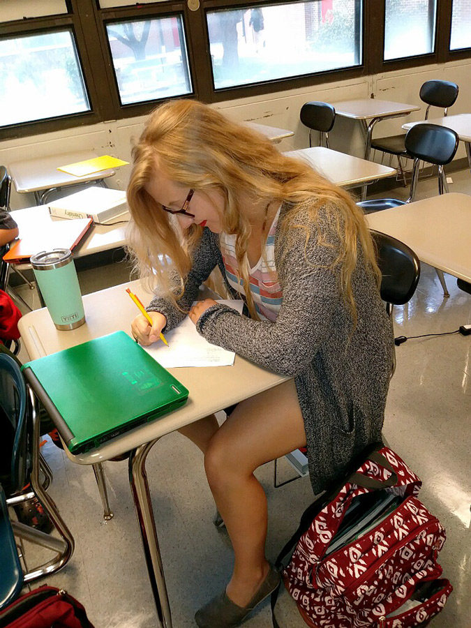 Senior Heylee Warren works on her homework during her spare time in chemistry class. She dressed as a hipster to represent her favorite genre during Homecoming Spirit Week.