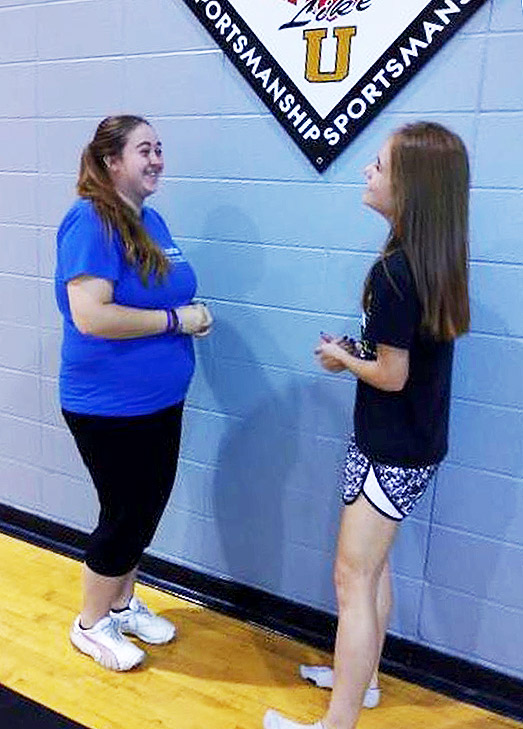 Senior Ruth Zumwalt visits with junior Veronica Brosam during PE class. Zumwalt recently changed schools from the ISD to Fort Osage and is adjusting to the new building.