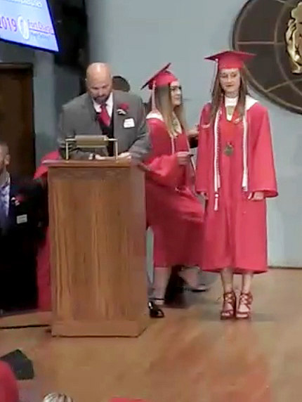 Reading each graduates name, Principal Scott Moore says Salutatorian Bailee Summers name as she goes to get her diploma. Each graduate received their diploma from a member of the Board of Education.