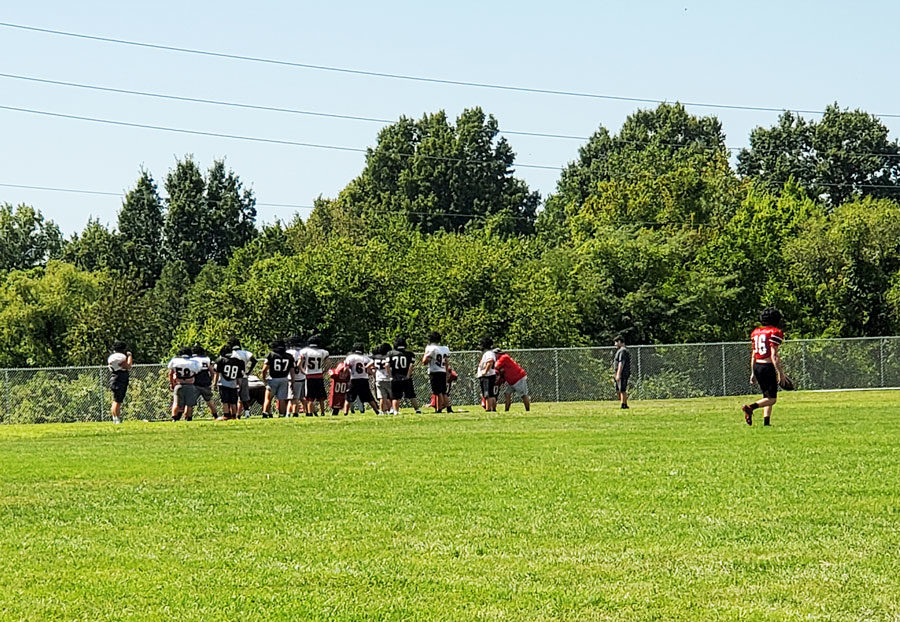 The varsity football team runs a play at a recent practice. The team begins the season on Aug. 30 at Raytown South.