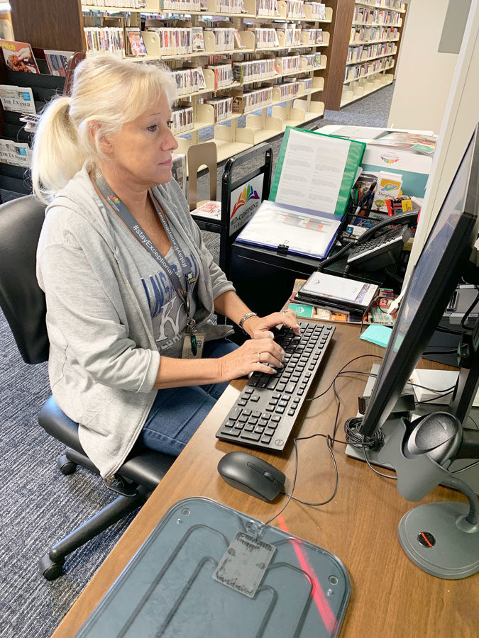 MCPL employee Luann Pilche works at her desk in the new Farview branch. The library is housed in the FOSDs old Early Childhood center at 18109 E. 12th St. N. in Independence.