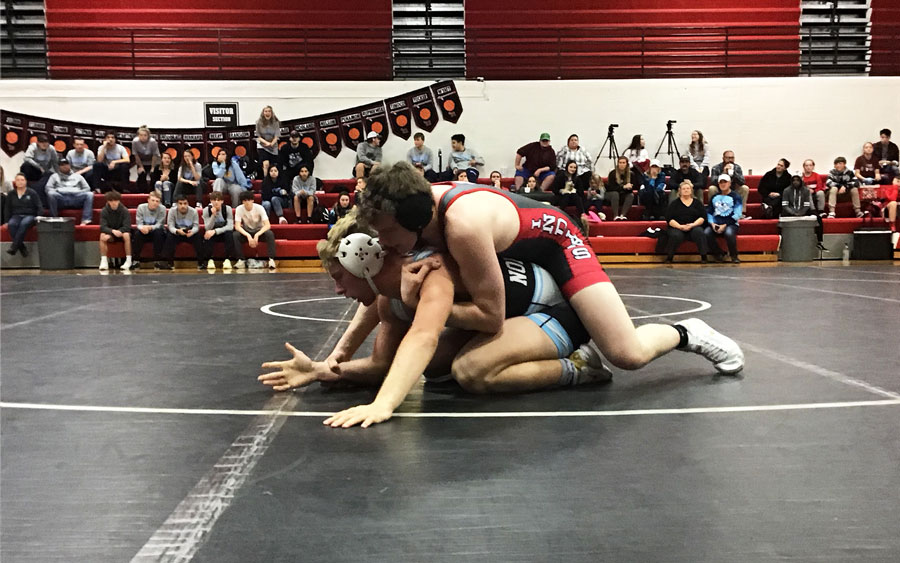 Looking for an opportunity to secure a hold, senior wrestler Jake Jones tries to break down Lucas Oitker of Oak Park in the 182 pound dual match on Jan. 8. Jones lost the match by decision 14-9.