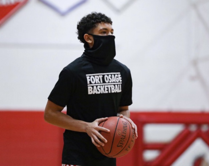 ADJUSTING TO THE TIMES. Running a pre-game drill, Senior Gabriel Franklin prepares to pass the ball. All sports have had to adjust to COVID-19 Restrictions which include social distancing, mask wearing and limited fan participation.