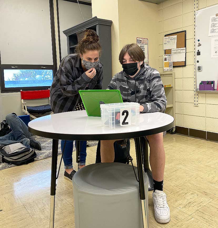 STAYING ON TASK. Working on an assignment, Ms. Morgan Ewing helps Sophomore Drew Warren solve a problem. Ms. Ewing started working for the school in January of this year.