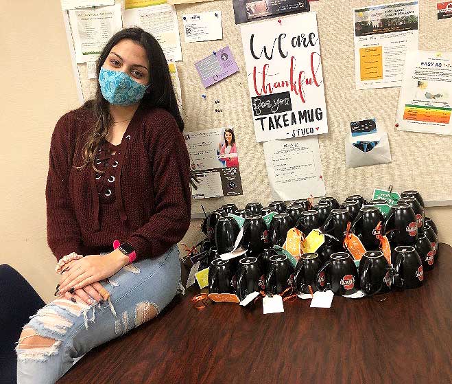 READY TO SERVE. Junior Grace Iloilo poses by the StuCo Teacher Appreciation gifts in the main teacher work room. The student body elected Iloilo to be the 2021-2022 Student Counsel President.