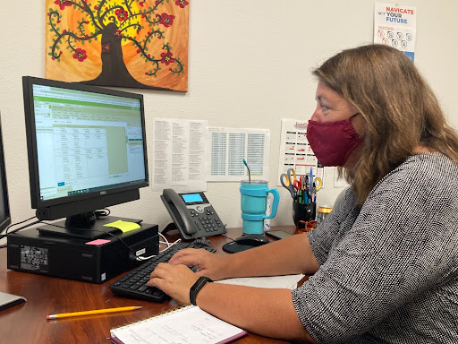 COMMUNICATING. Aligning a students schedule, Counselor Nancy Young makes sure the student is in the correct classes. Ms. Young came out of retirement to work at the school.