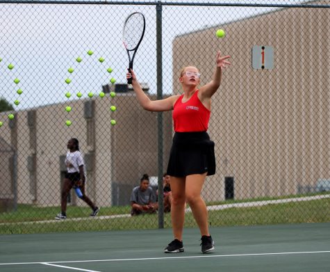SERVE. Tossing the ball in the air, senior Alanis Cameron served during her singles match against Grandview. The team beat the Bulldogs 9-0 on senior night.