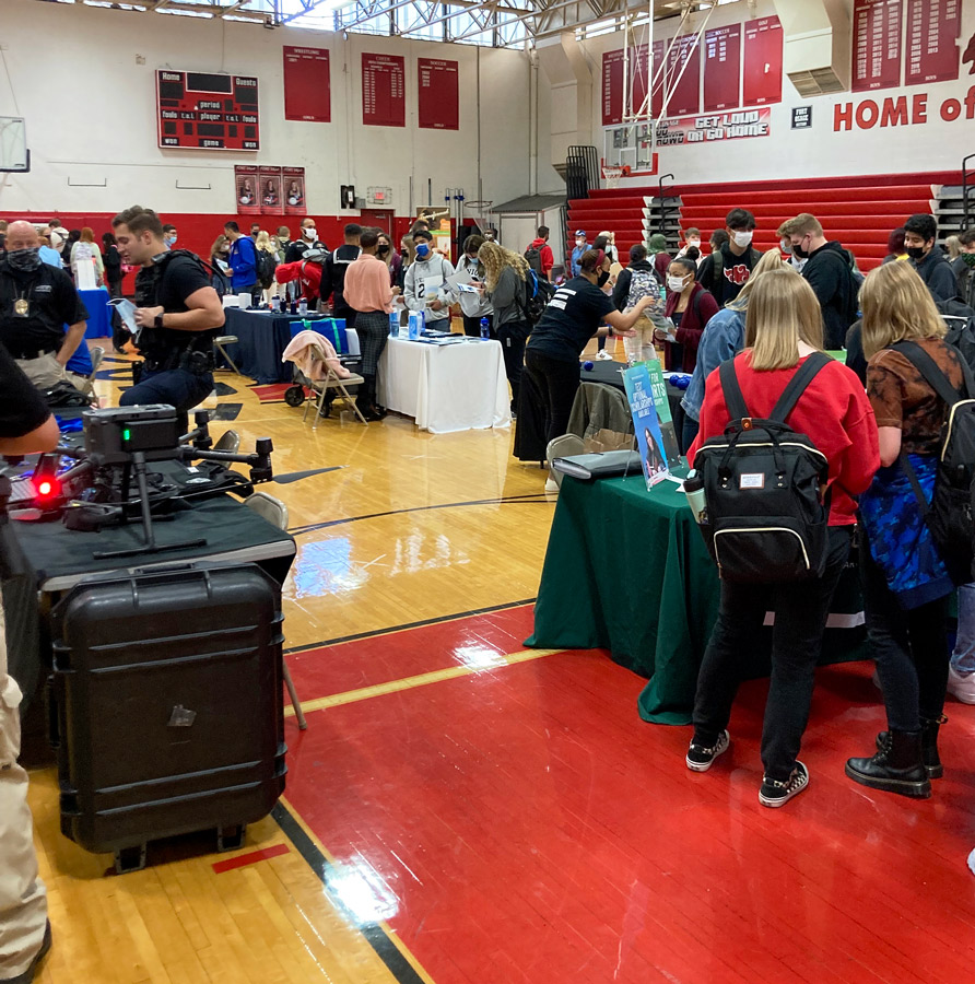 GETTING INFORMED. Packing the varsity gym, students visit various college booths to find out  more about each school. This was the first Career and College day offered by the school.