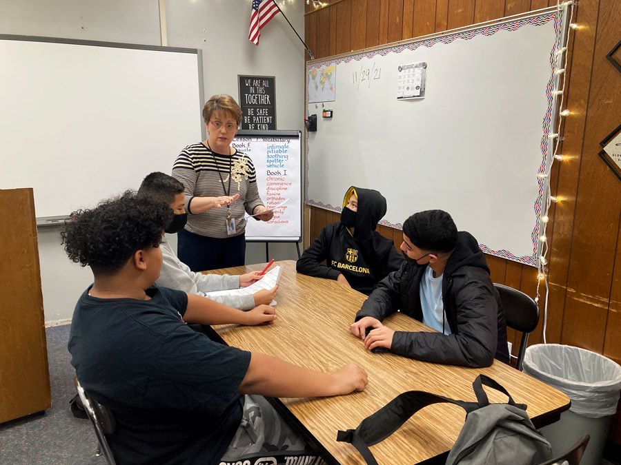 TRANSLATE. Standing at the head of the table, Ms. Vicky Alves works on translating various languages into the English language for her ELL students. Ms. Alves began teaching at FOHS at the beginning of the 2021-2022 school year.