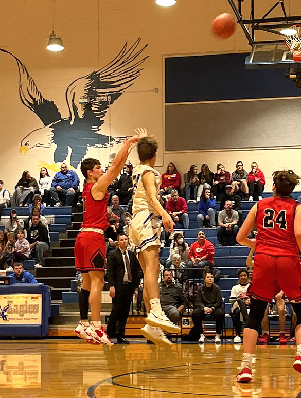 JUMP SHOT. Getting the ball over the defender, Senior Trent Hogland (L) attempts a three point shot. The Indians lost to to Grain Valley 48-45.