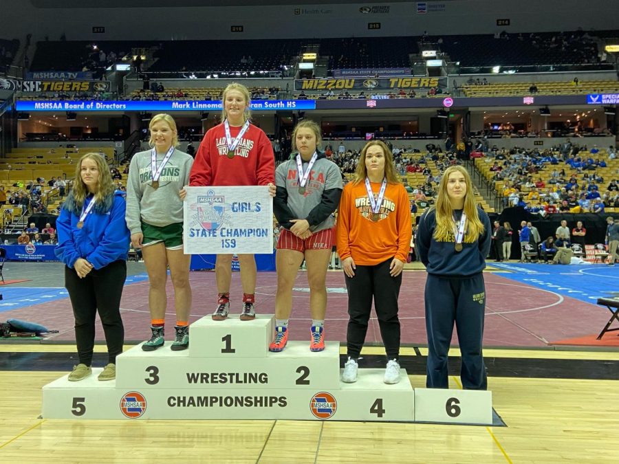 TOP+OF+THE+PODIUM.+Holding+the+title+card%2C+Junior+Haley+Ward+stands+in+the+champions+spot+for+the+159+weight+class+at+the+2022+MSHSAA+Girls+State+Wrestling+tournament.+This+is+Wards+3rd+State+Title.+