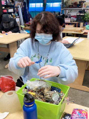 CREATIVE RECYCLING. Being selective, Senior Annabelle Andy McLaughlin looks through recycled materials for a project. He plans on pursing an Art degree at the KC Art Institute.