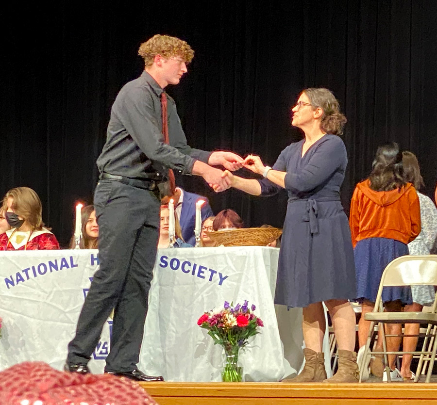 HONORED.  Junior Brady Darr receives his pin from National Honors Society Co-Sponsor Ms. KassieGravely. NHS is built upon four pillars: scholarship, responsibility, service, and leadership.