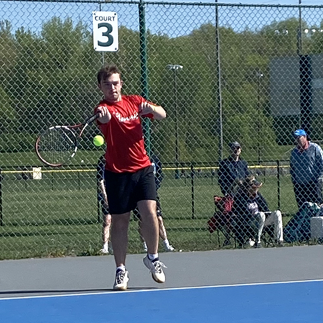RETURN SERVE. Striking the ball, Senior Malcolm Davis competes in the District Tournament May 7. Davis led the team as the No. 1 singles slot on the tennis team.