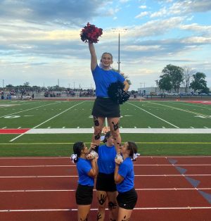 STUNT. Holding her pom poms up, Senior Cheerleader Jozie Krevitz (C) balances on her teammates Seniors Lohany Galeas (L), Brielle Redinger (M) and Courtney Canzonere (R). Krevitz has not decided on a college yet, but she is looking into studying health science and to participate in cheer.