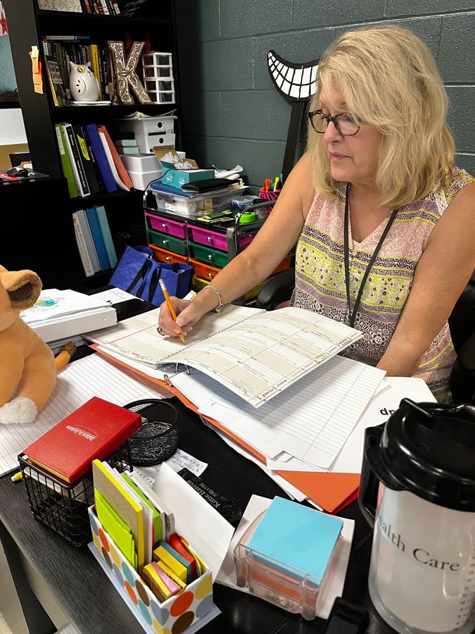 MOVING FORWARD. Thinking about upcoming classes, Ms. Harden jots down plan notes. She has been teaching theater for over 30 years. Ms. Harden’s advice to novice actors is to “Audition! Sign up! Be involved! Jump in and do it!”