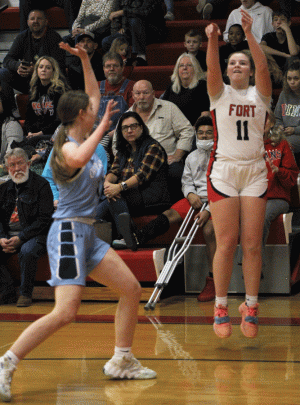 THREE. Jumping in the air, Senior Ashlyn Buntin (11) attempts a three pointer over an Oak Park defender early in the second quarter. Buntin had three steals in the game. “I feel like our defense was probably the thing we did best honestly, and our transition points were really good too,” Buntin said.