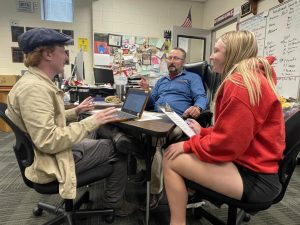 COLLABORATING. Sharing an idea, Mr. Benjamin Merithew (Center) discusses news coverage with Juniors Dylan Daugherty (Right) and Jazmyn Jazzy Walker (Left). Mr. Merithew resigned April 28 to take a new position at Park Hill High School in Kansas City. I will miss the day-to-day interactions with my colleagues and students at Fort, Mr. Merithew said. But Im looking forward to the opportunity to grow at Park Hill.