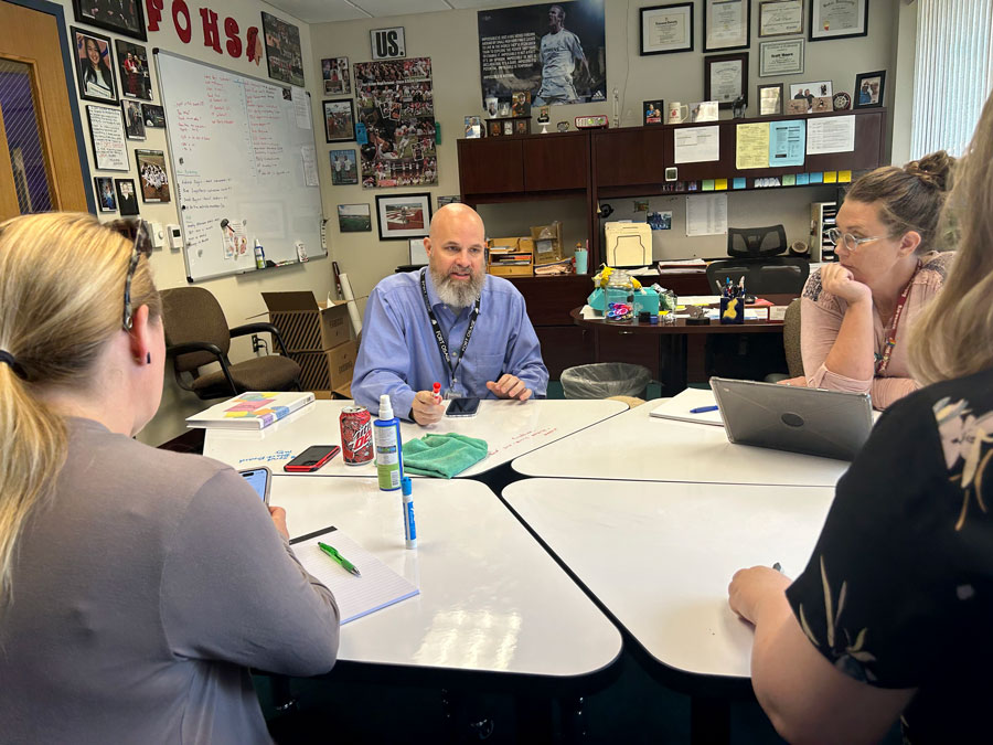 OBSERVING. Head principal Scott Moore (C) takes notes during a meeting over the phone with Deanna Rymer (RB) and Assistant Principal Tracie Gramkow (L). During his tenure as principal, Mr. Moore received The Missouri Association of Student Council West District Administrator of the Year in 2019. ¨Fort Osage has changed my life and I hope people understand why I made the decision I did,¨ Mr. Moore said. 