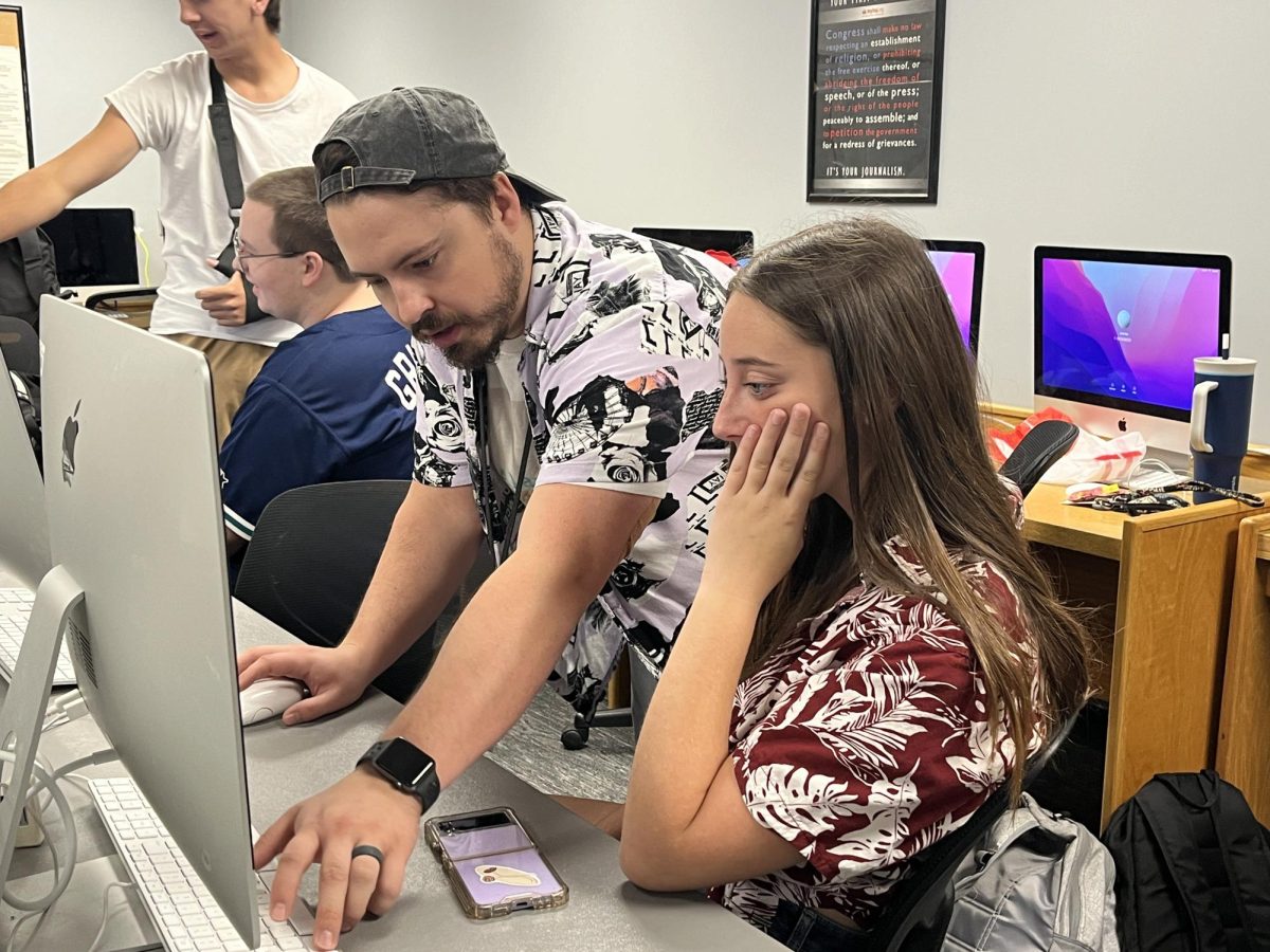 PRODUCING. New broadcast teacher Chance Parsons (left) helps Senior Neveah McNew (right) with creating a soccer hype video. Mr. Parsons has previously worked broadcasting sports teams, “Some of my favorite broadcasting moments were when we had to do a Royal parade and a Chiefs parade,” Parsons said, “and just getting to see the behind the scenes of them was amazing.”