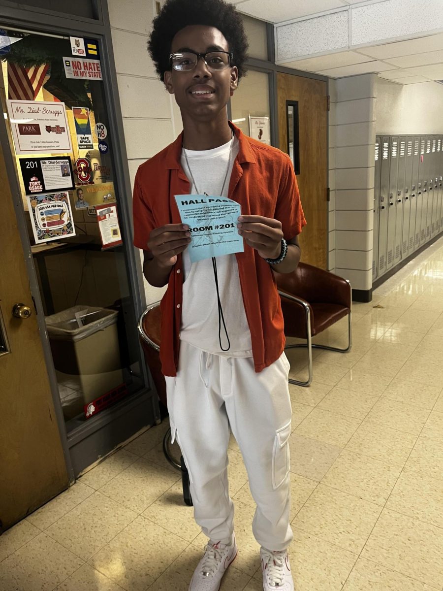 PASSING BY: Junior, Marcus Wilson, poses with the 201 hall pass on his way to the restroom.