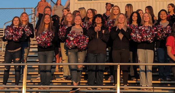 CHEERING. The dance team watches as Johnny Rowlands lands his helicopter on the football field. The dance team got to the school at 6:30am. “I loved when the cheer team and dance team were all cheering together,” Sophie Dech said.
