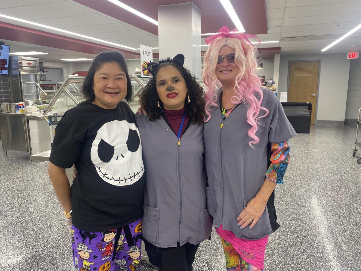 DRESSING UP WITH CO-WORKERS. Cafeteria and Janitorial staff poses showing off their Halloween outfits.