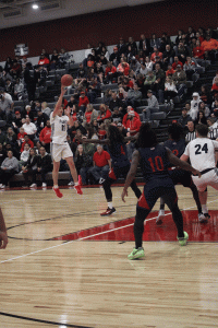 STRETCHING OUT. Senior Cruz Navarro searches for an open player  in their 54-60 loss to the Truman Patriots during the home opener of the new field house. "We didn't show up, and played as hard as we could have," Navarro said.