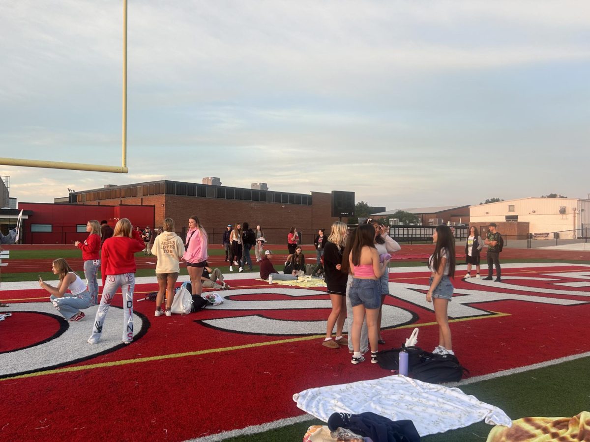 RELAXING. Students gather at the football field to watch the sunrise to talk and enjoy the beginning of senior year. Senior Peyton Friesz believes that it is bittersweet being seniors. ¨We have grown up together as a class,” Friesz said. ¨Our time is finally here.¨