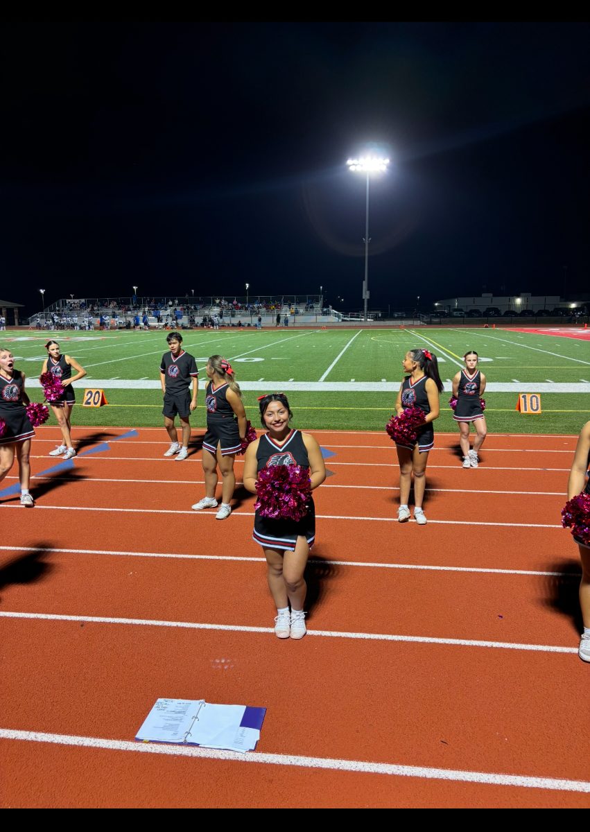 On the sidelines Isabel Baggs captain of the Indians cheer team, cheers as the Indians football team runs for the touch down.  