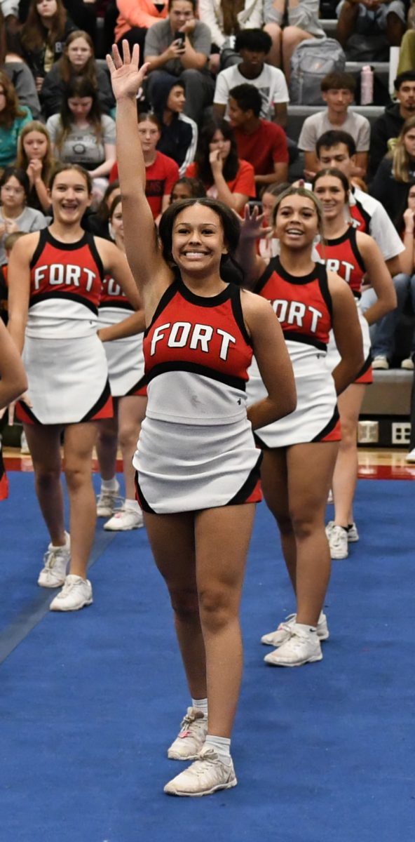 Kylie Corum, senoir, performs with the cheer squad during the Homecoming assembly.